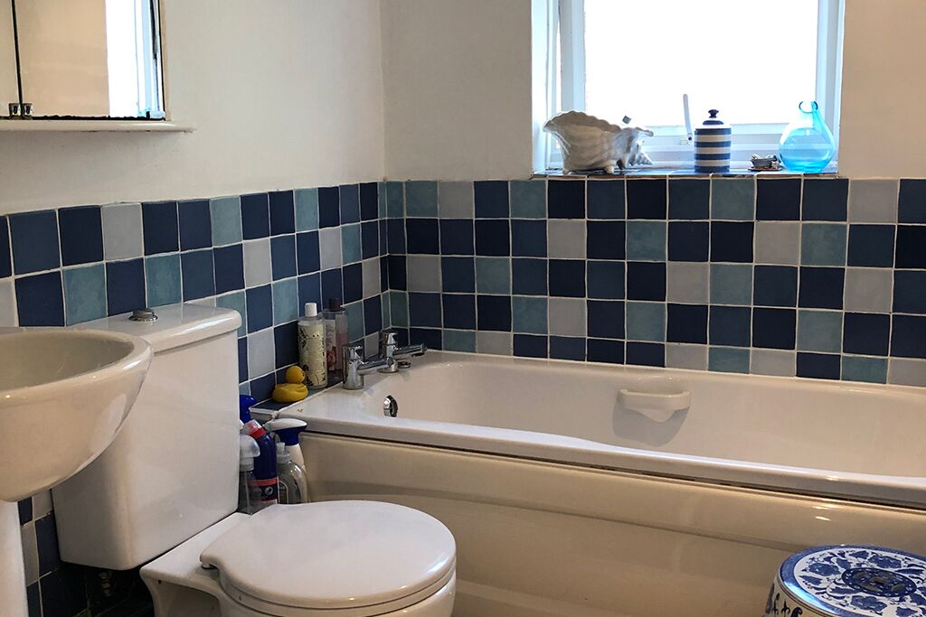 Toilet, sink and bathtub with blue and white tiles